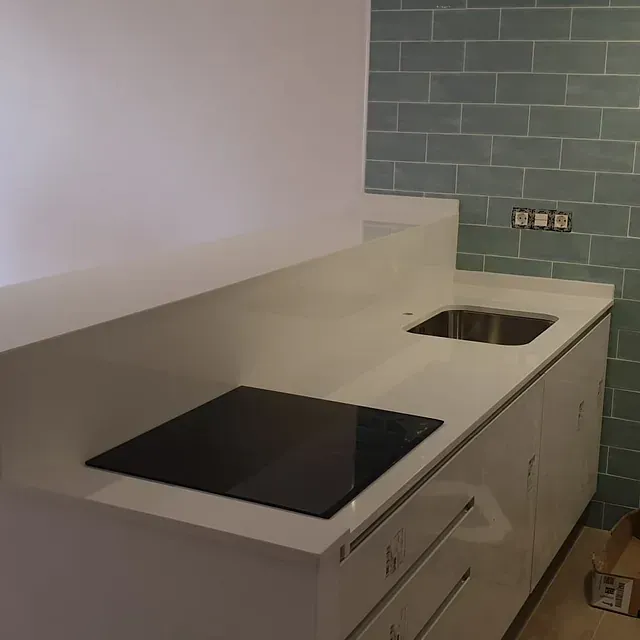 Una cocina con una estufa negra y un fregadero.