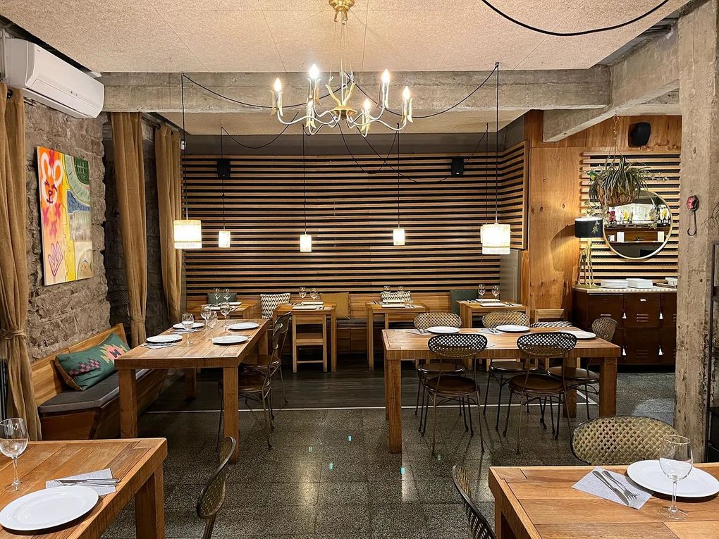 Un restaurante con mesas y sillas y una lámpara de araña.