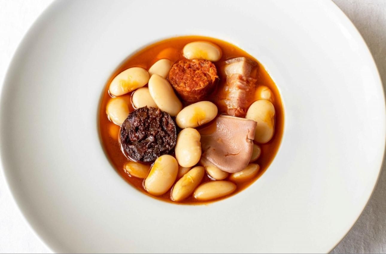 Champiñones, huevo y hierbas en un recipiente de cerámica, con verduras de fondo.