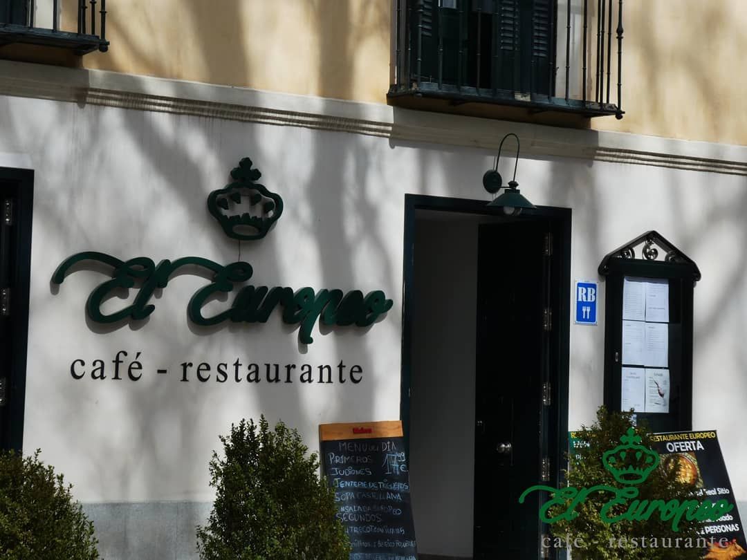 Café-restaurante El Europa con señalización verde, logo de una corona y menú en un día soleado.