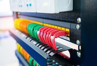 Un montón de cables cuelgan de un estante en una sala de servidores.