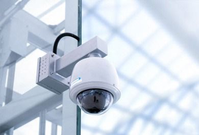 Una cámara de seguridad cuelga del techo de un edificio.