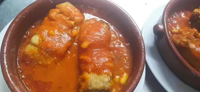 Dos tazones de comida con salsa de tomate en un plato blanco.