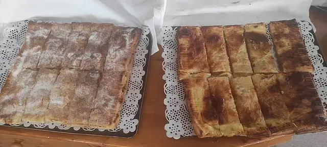 Dos bandejas de pasteles están sobre una mesa de madera.