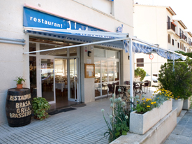 Un restaurante con un toldo azul y un cartel que dice restaurante.