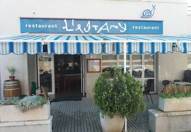 Un restaurante con un toldo de rayas azules y blancas.