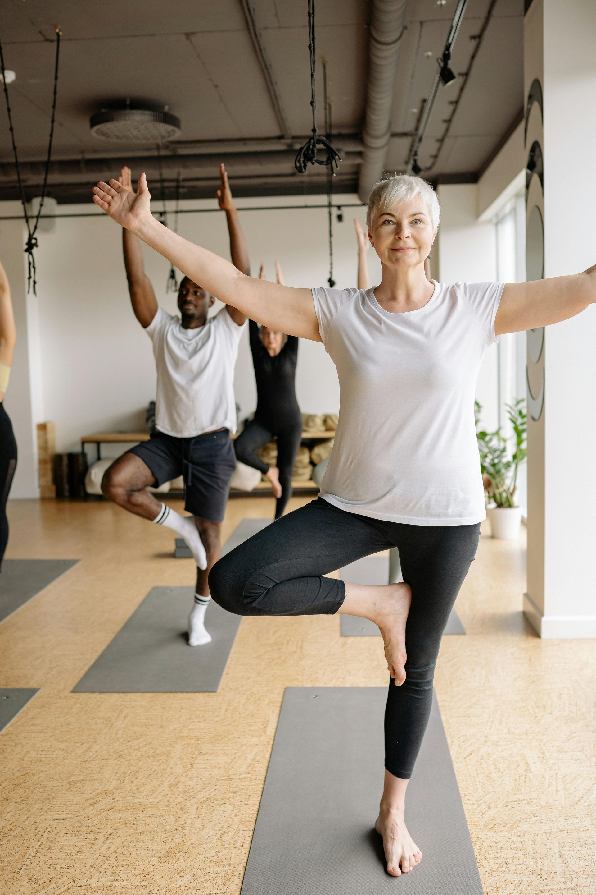 Un grupo de personas están haciendo yoga juntas en un gimnasio.