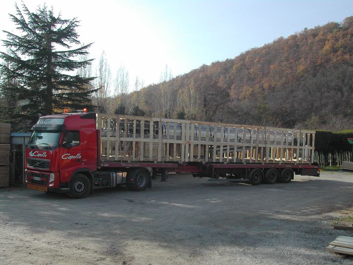 Camion rouge avec une grande remorque avec une structure en bois 