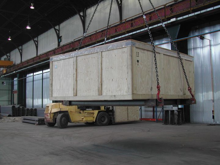 Dans un entrepôt, une grande caisse en bois