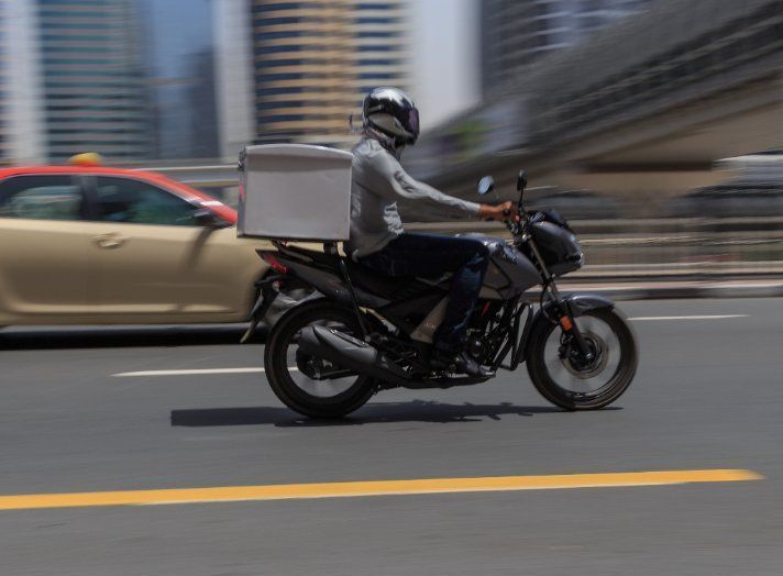 Un hombre conduce una motocicleta por una calle de la ciudad.