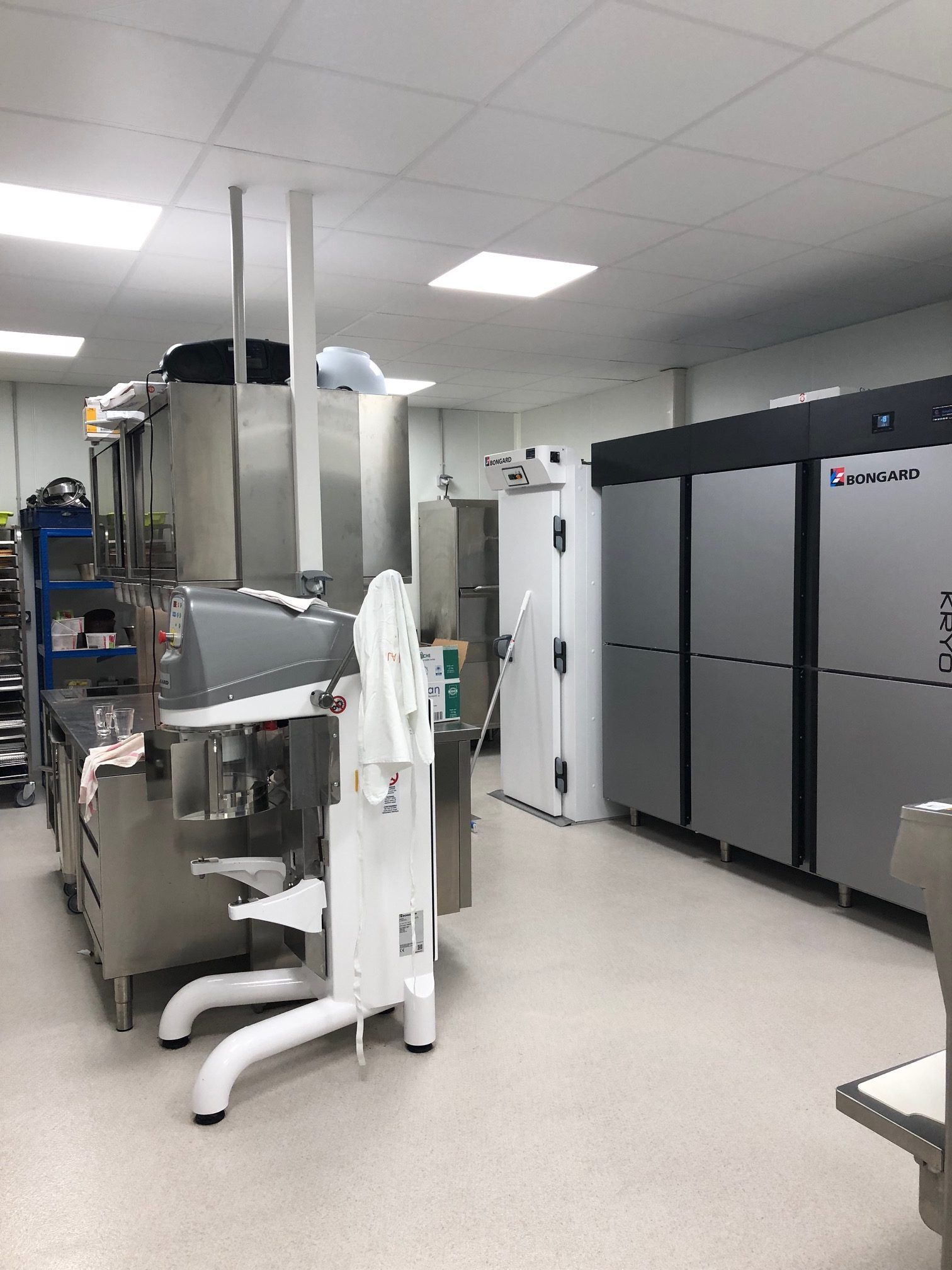 Cuisine professionnelle équipée de matériel en acier inoxydable et de réfrigérateurs.