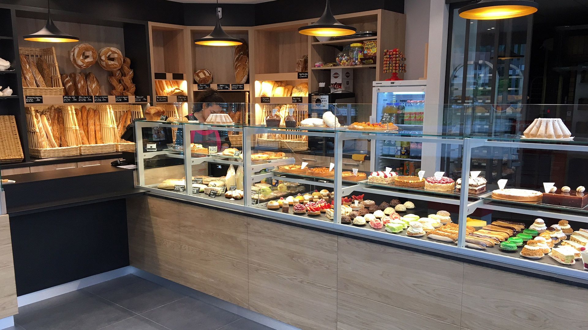 Vitrine de boulangerie remplie de viennoiseries et de pains ; éclairage zénithal.