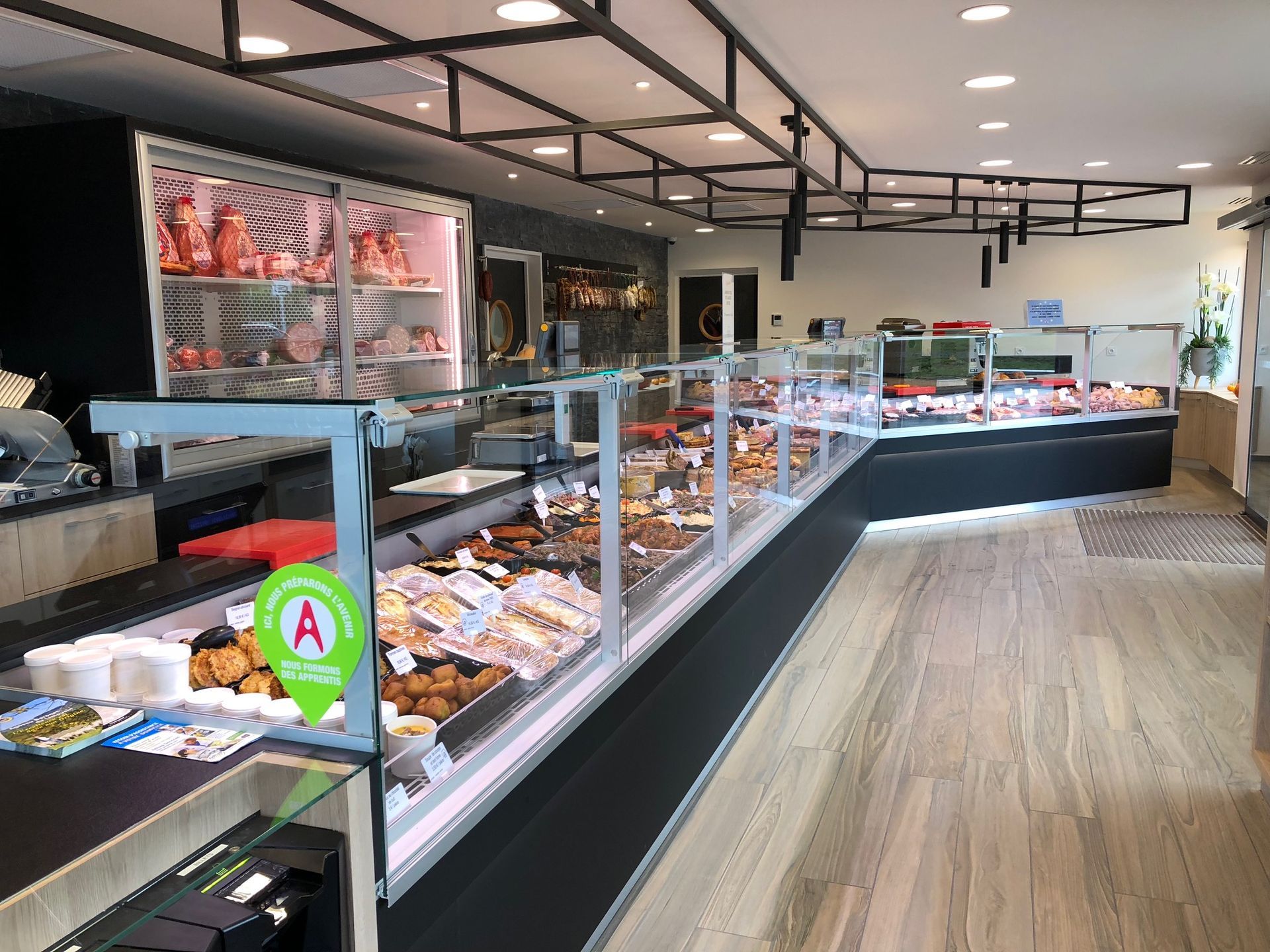 Boucherie avec vitrines de viande et de plats préparés, vue intérieure.