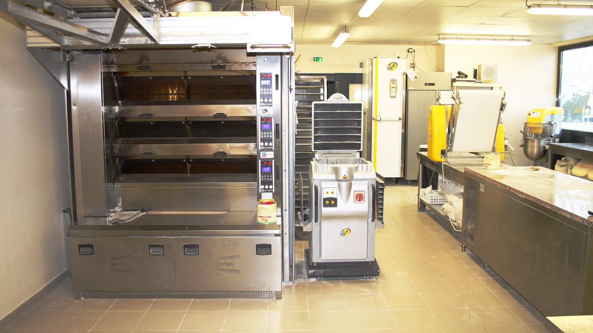 Boulangerie commerciale avec un grand four, d'autres équipements et des surfaces de travail.