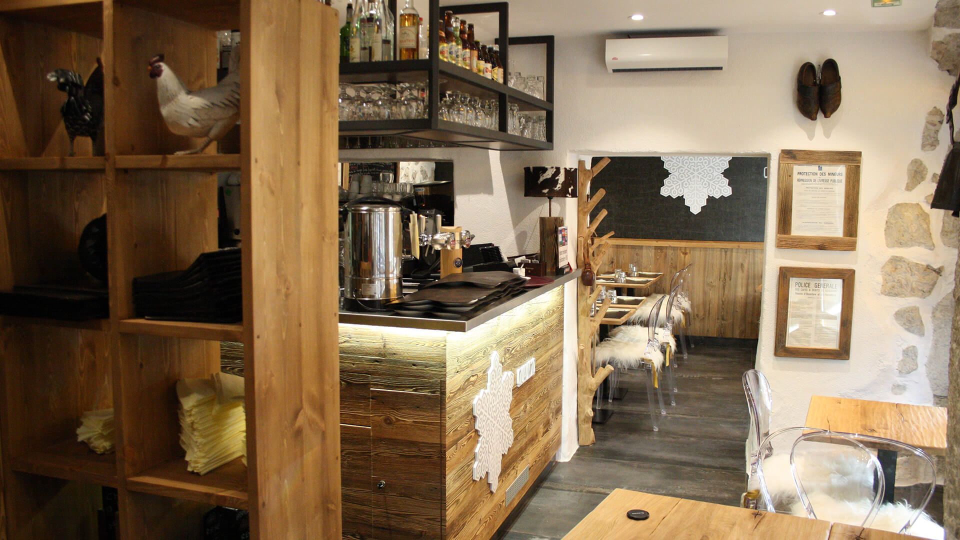 Intérieur du restaurant avec étagères en bois et bar, orné de poulets empaillés et d'un mur tableau noir.