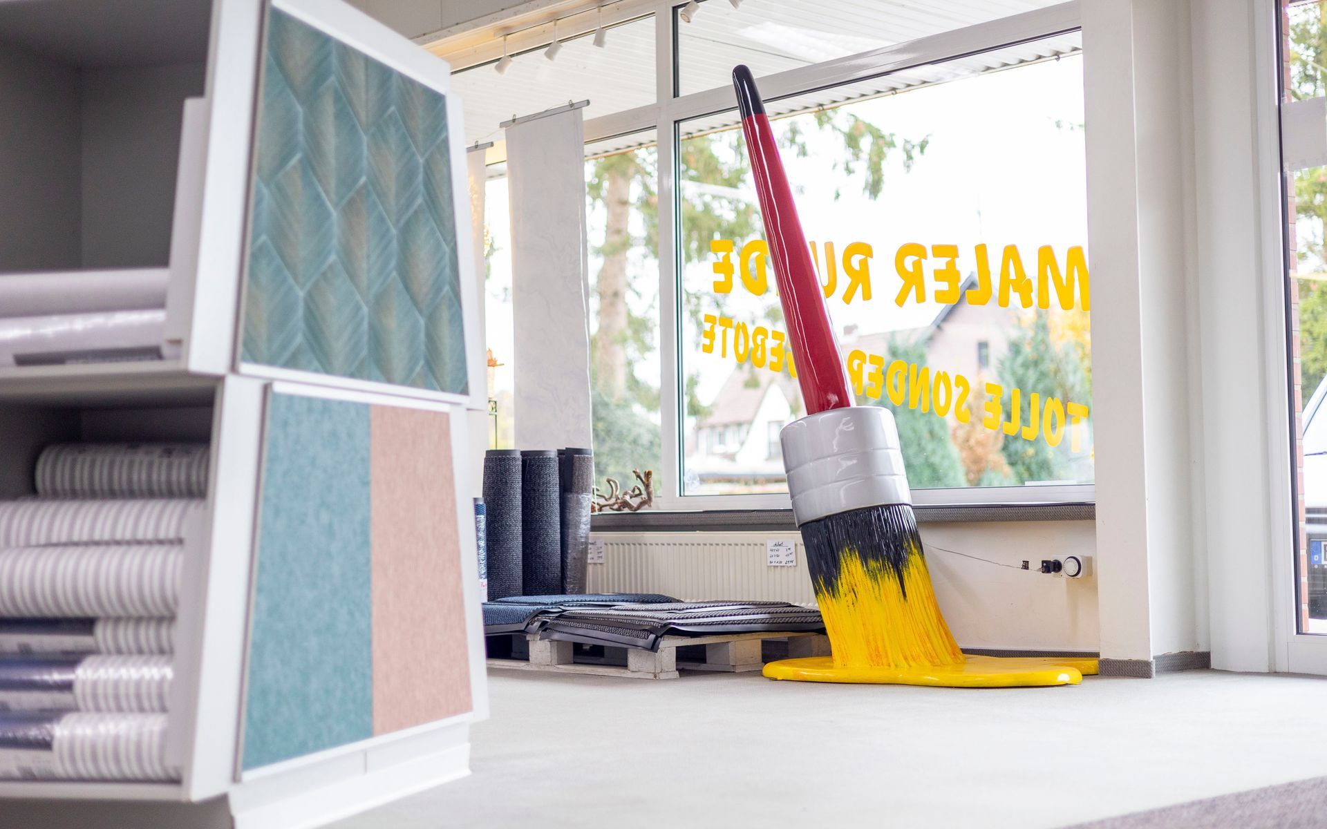 Ein gelber Mopp liegt auf dem Boden vor einem Fenster, auf dem 