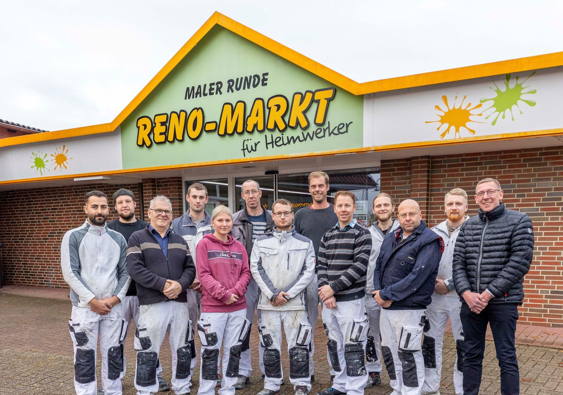 Eine Gruppe von Menschen posiert vor einem Gebäude für ein Foto.