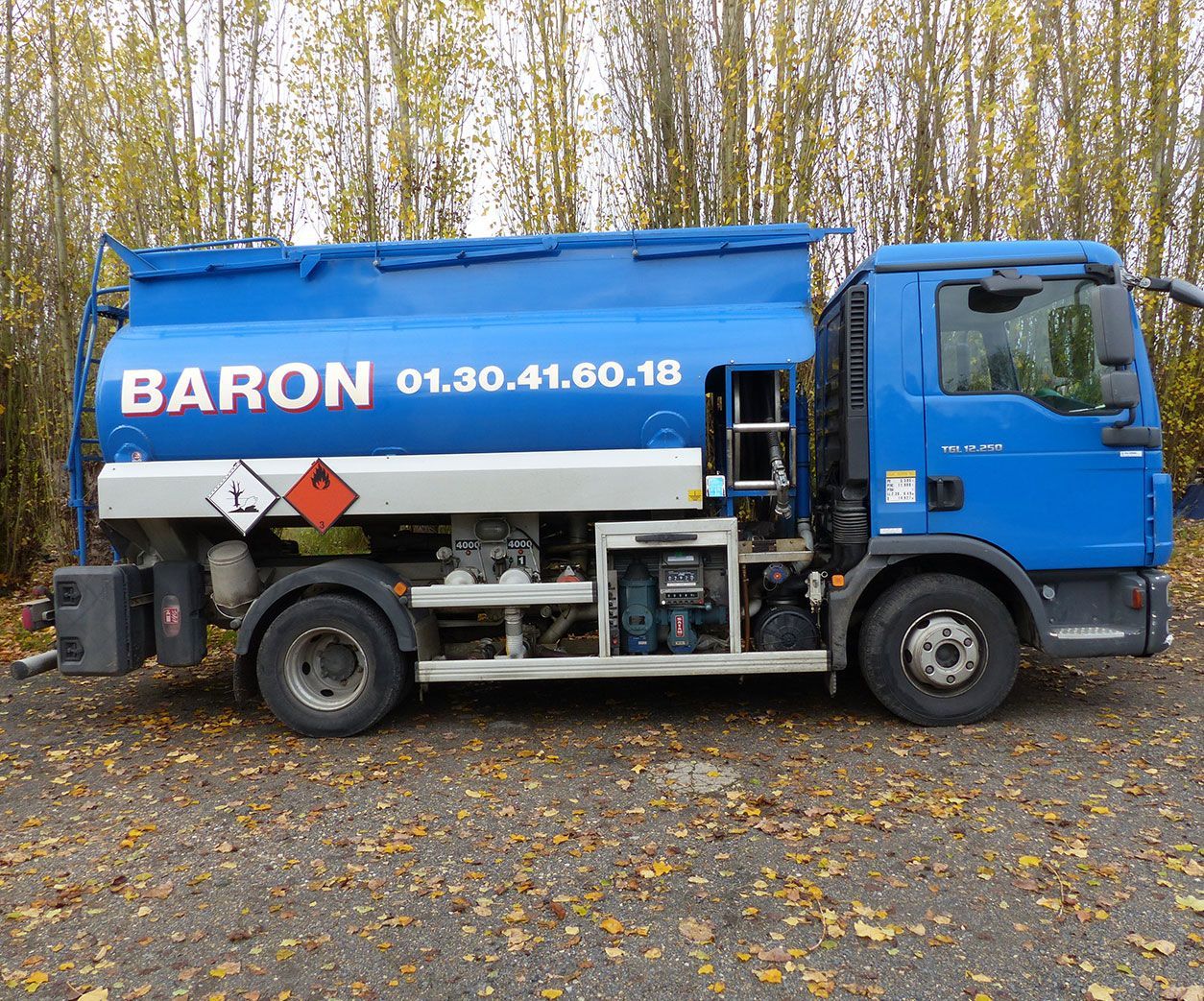 Camion-citerne Blue Baron stationné sur du gravier.