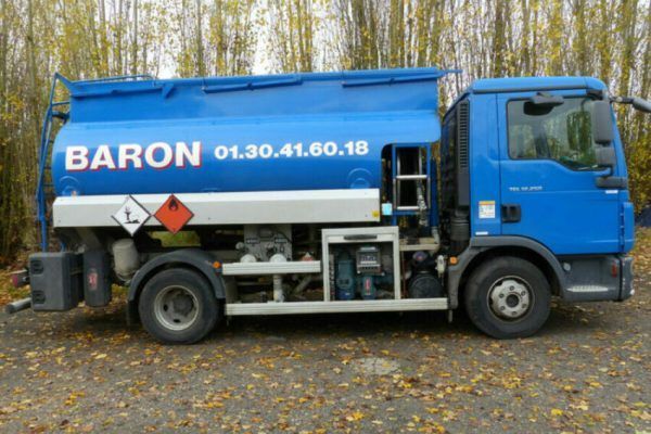 Camion-citerne bleu avec le logo « BARON » et un numéro de téléphone, stationné à l'extérieur.