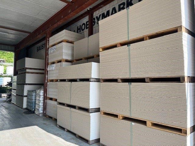 Gestapelte Paletten Gestapelte Paletten mit weißen Fliesen oder Platten sind in einer Laderampe eines Lagerhauses gelagert.