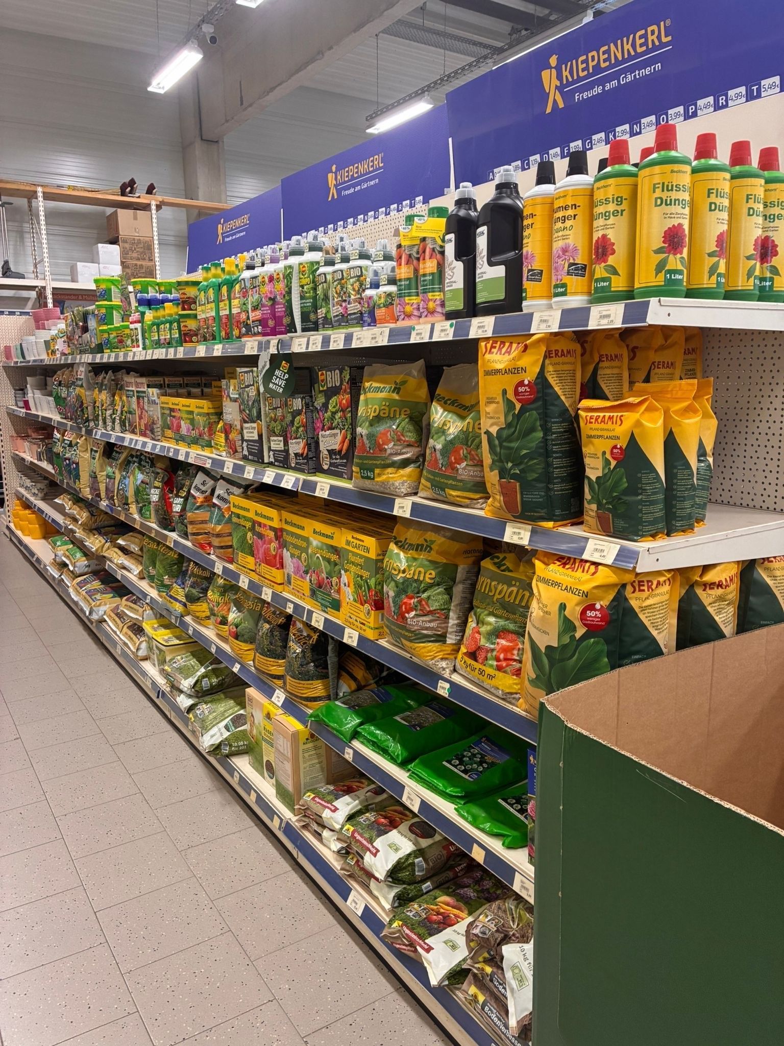Supermarktregal mit abgepackten Snacks und Flaschen in leuchtend gelben und grünen Verpackungen