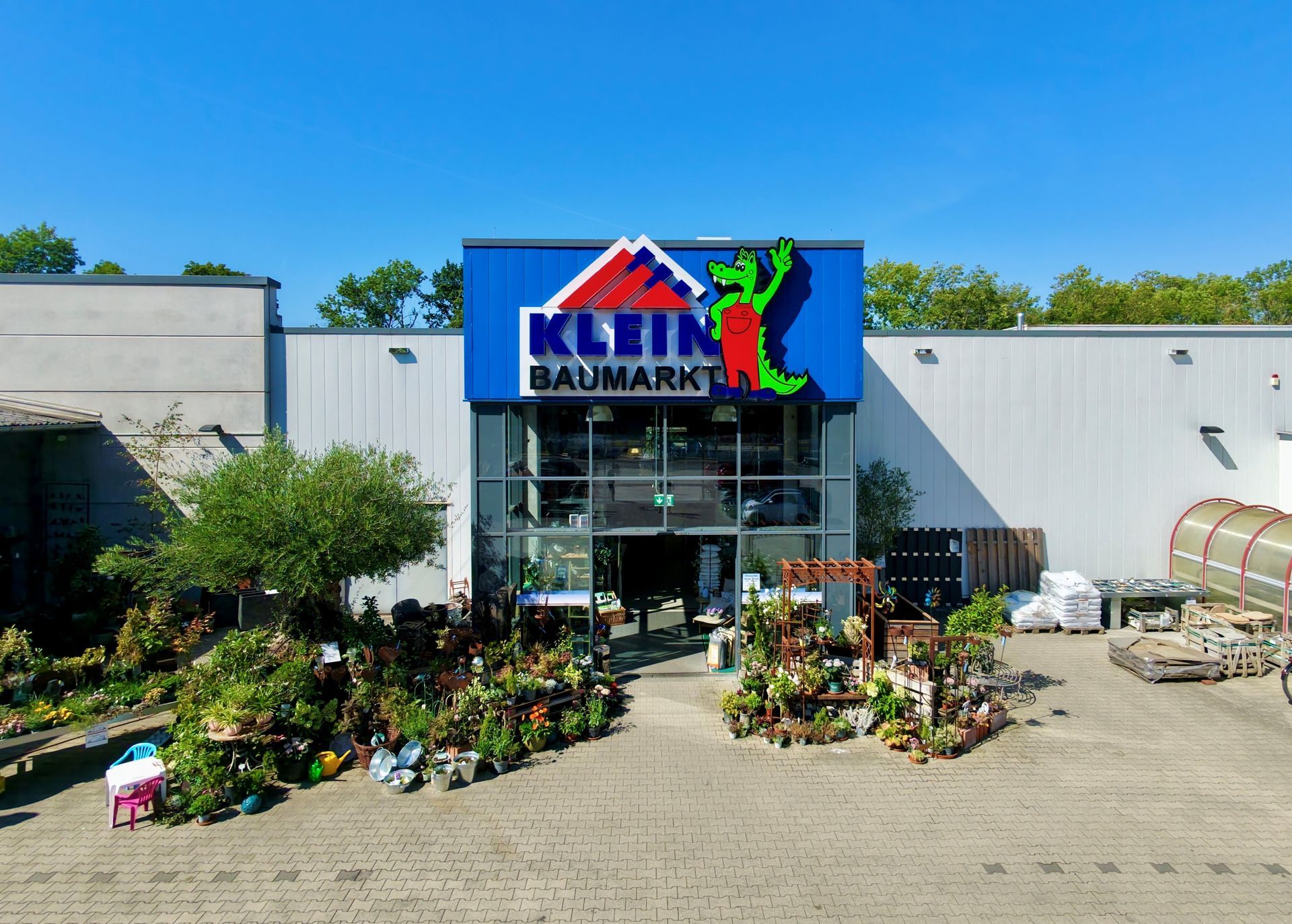 Schaufenster eines Gartencenters mit einem großen blauen Schild.