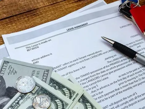 Un formulario 1040 de declaración de impuestos sobre la renta individual de EE. UU. está encima de una pila de dinero.