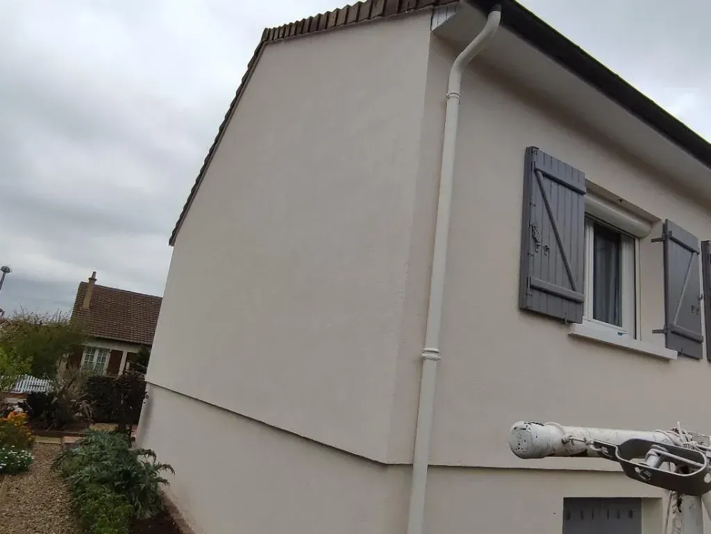 Pose d'enduit taloché sur une façade avec peinture de gouttière