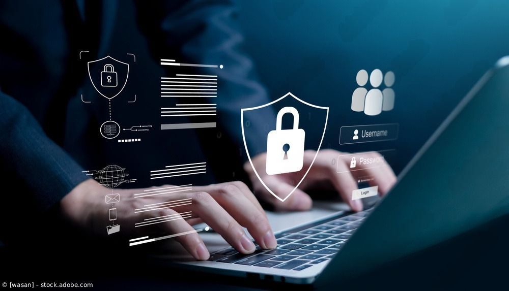 Hände tippen auf einem Laptop mit Cybersicherheitssymbolen und einem Schloss-Overlay auf blauem Tech-Hintergrund