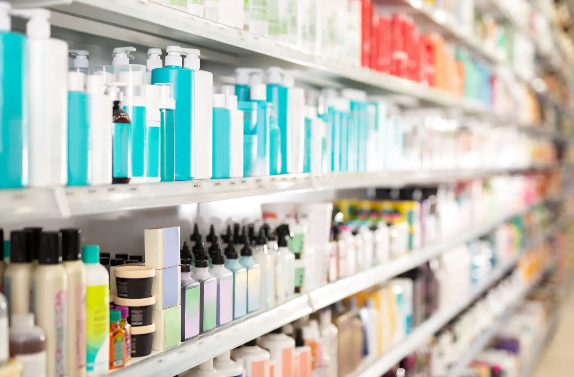 Una imagen borrosa de un pasillo de farmacia lleno de productos de belleza.