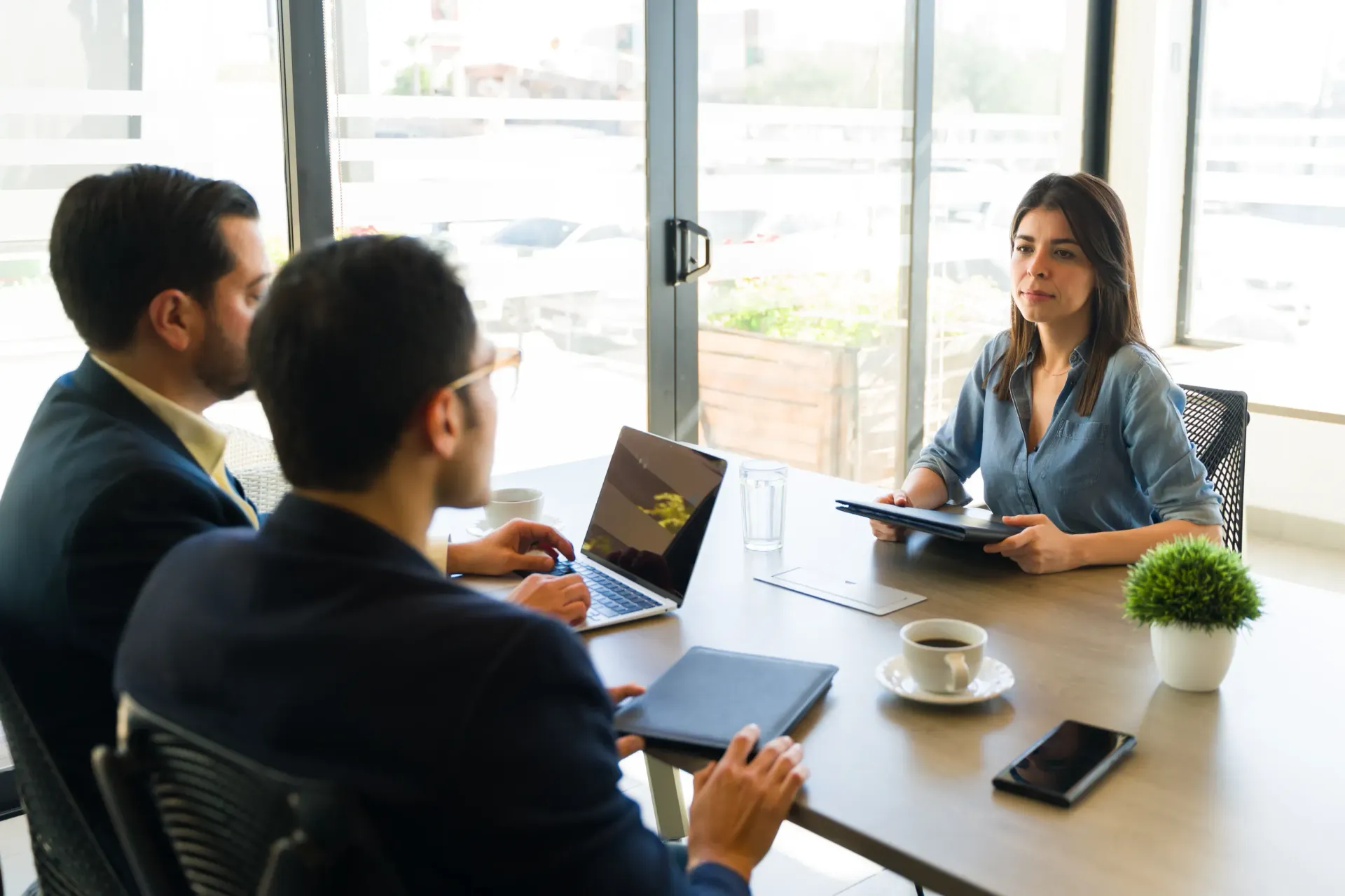 Un grupo de personas están sentadas alrededor de una mesa teniendo una reunión.
