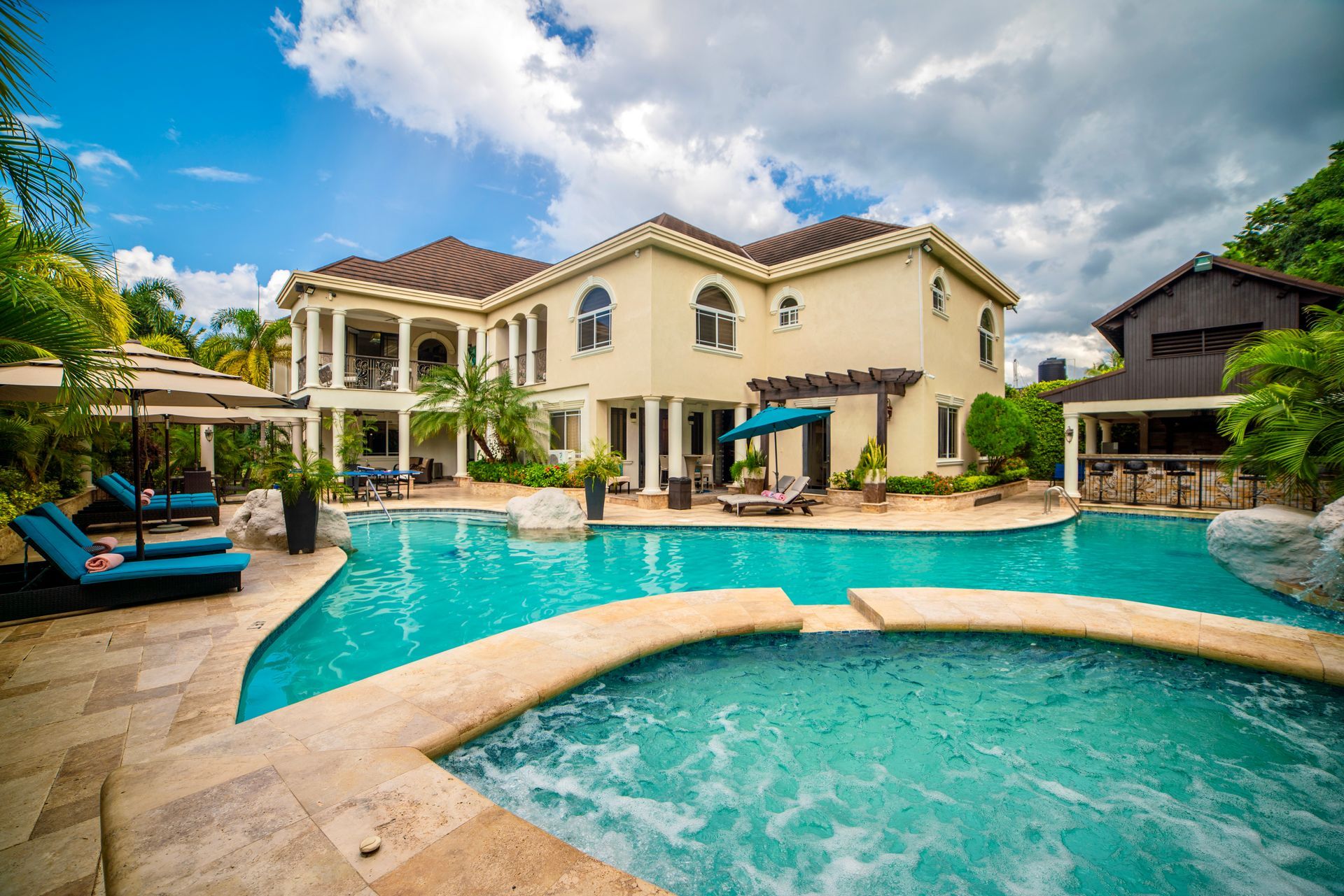 A large house with a large swimming pool in front of it.