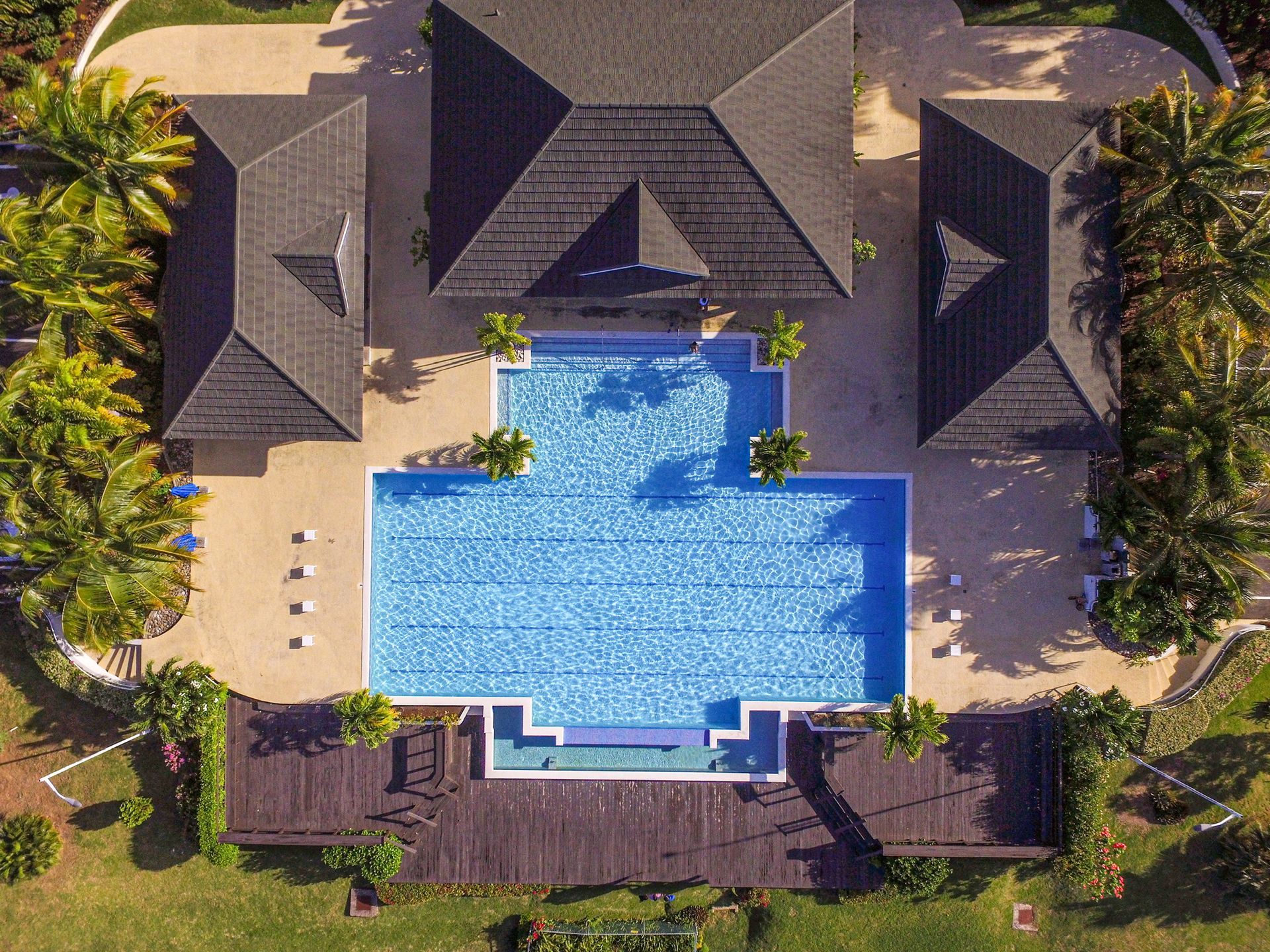 An aerial view of a large swimming pool surrounded by houses