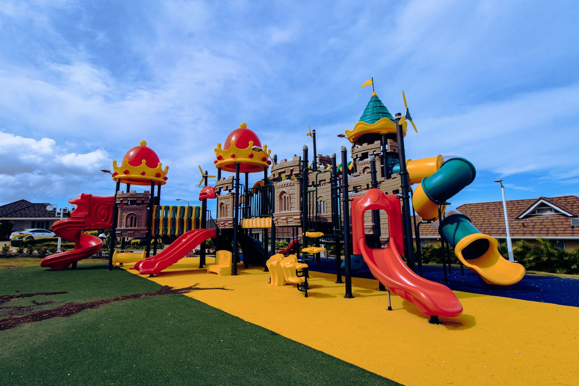 A colorful playground with a slide and a castle in the background