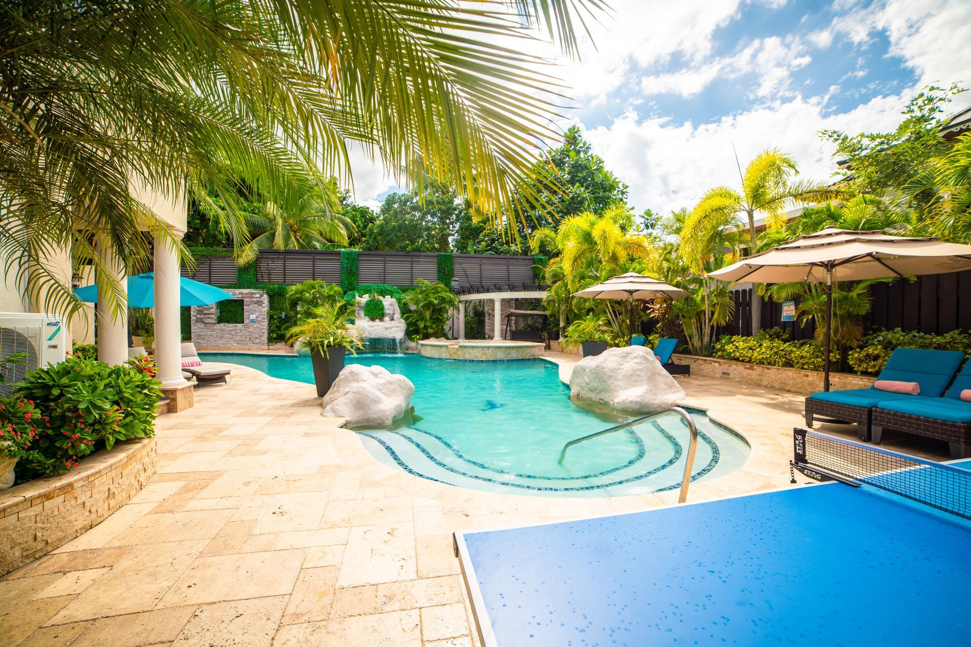 A large swimming pool surrounded by blue chairs and umbrellas