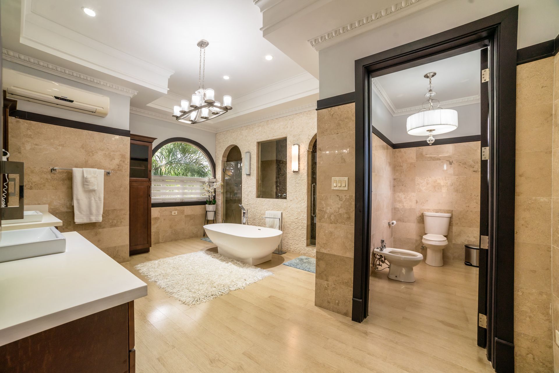 A bathroom with a tub , toilet , sink and mirror.