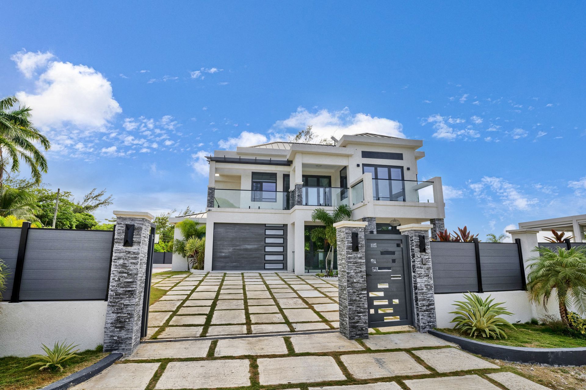 Two-story white house behind a fence labeled