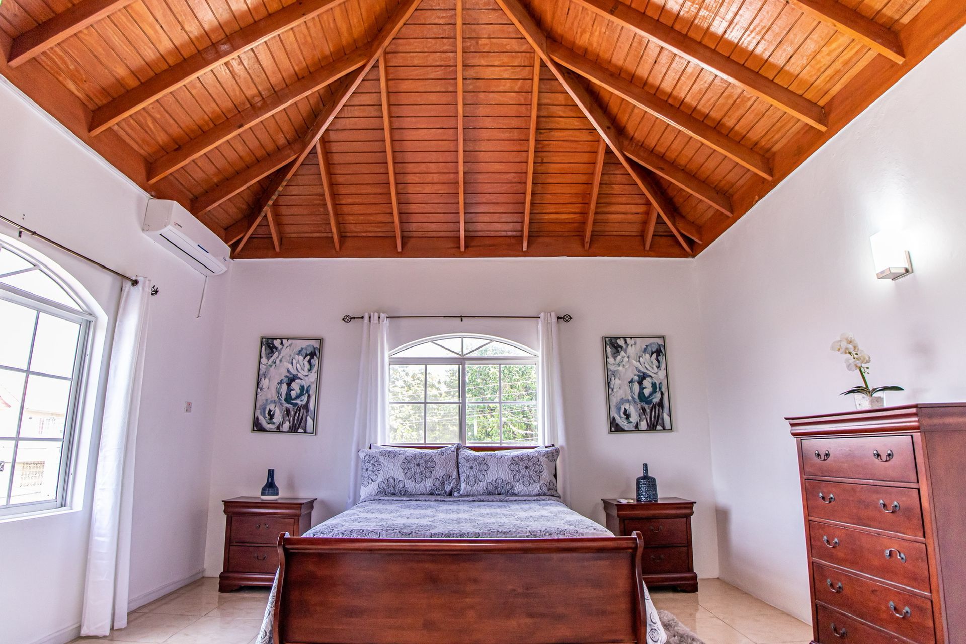 A bedroom with a wooden ceiling and a bed