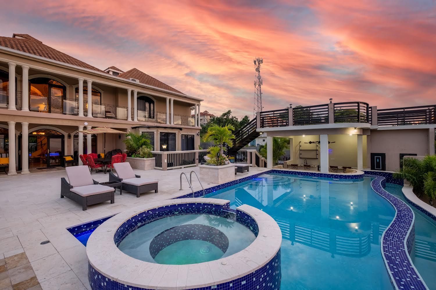 A large swimming pool with a hot tub in the middle of it