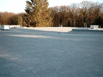 Ein leerer Parkplatz mit Bäumen im Hintergrund