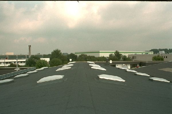 Die Sonne scheint durch die Wolken über dem Dach eines Gebäudes