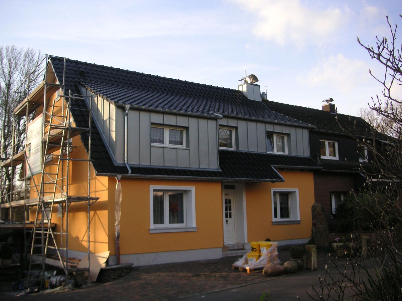 Ein gelbes Haus mit schwarzem Dach ist im Bau