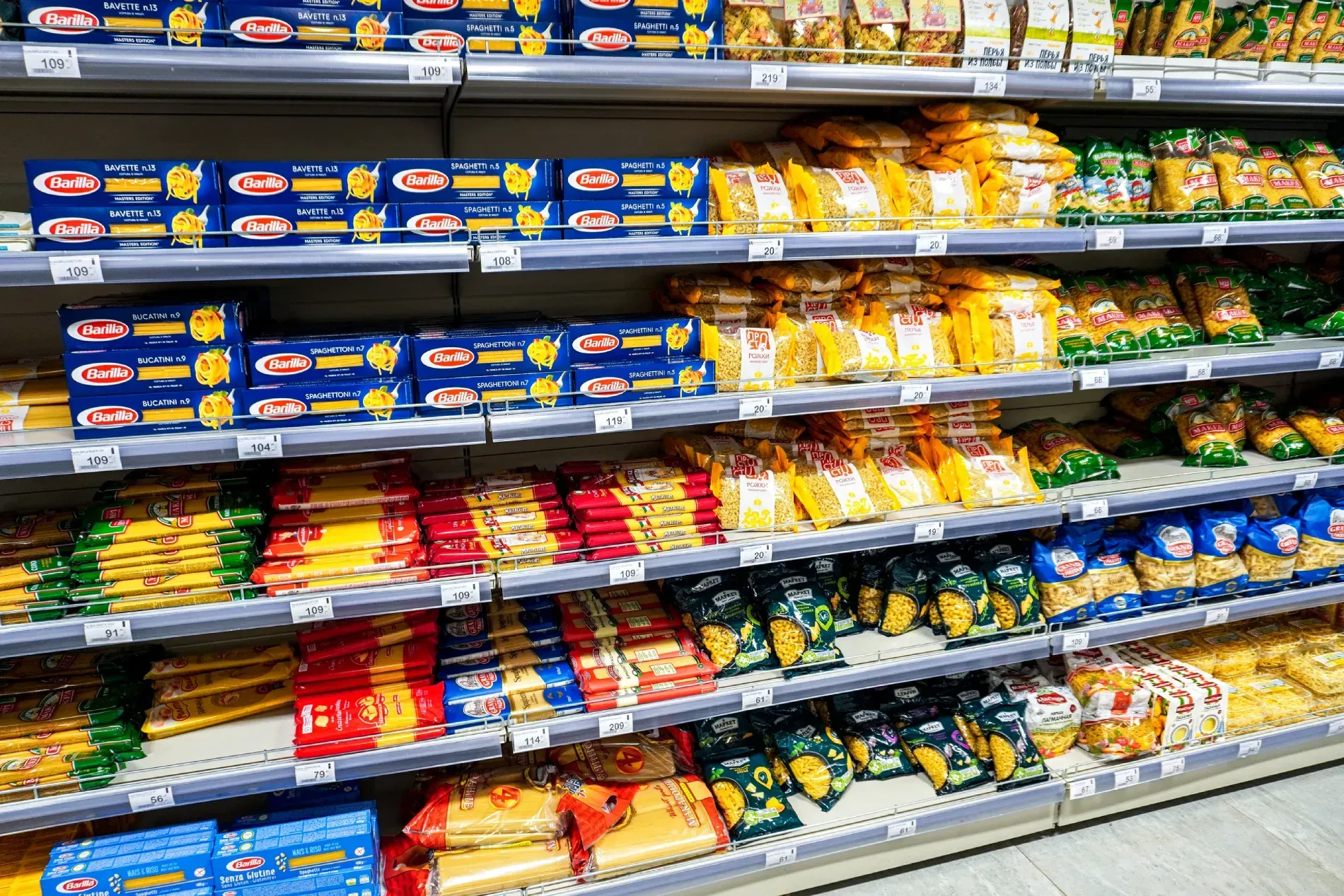 Un pasillo de una tienda de comestibles lleno de muchos tipos diferentes de pasta.
