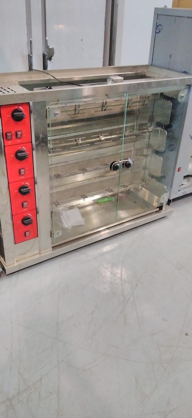 Vitrina de cristal con panel de control rojo, ubicada en un laboratorio o taller.