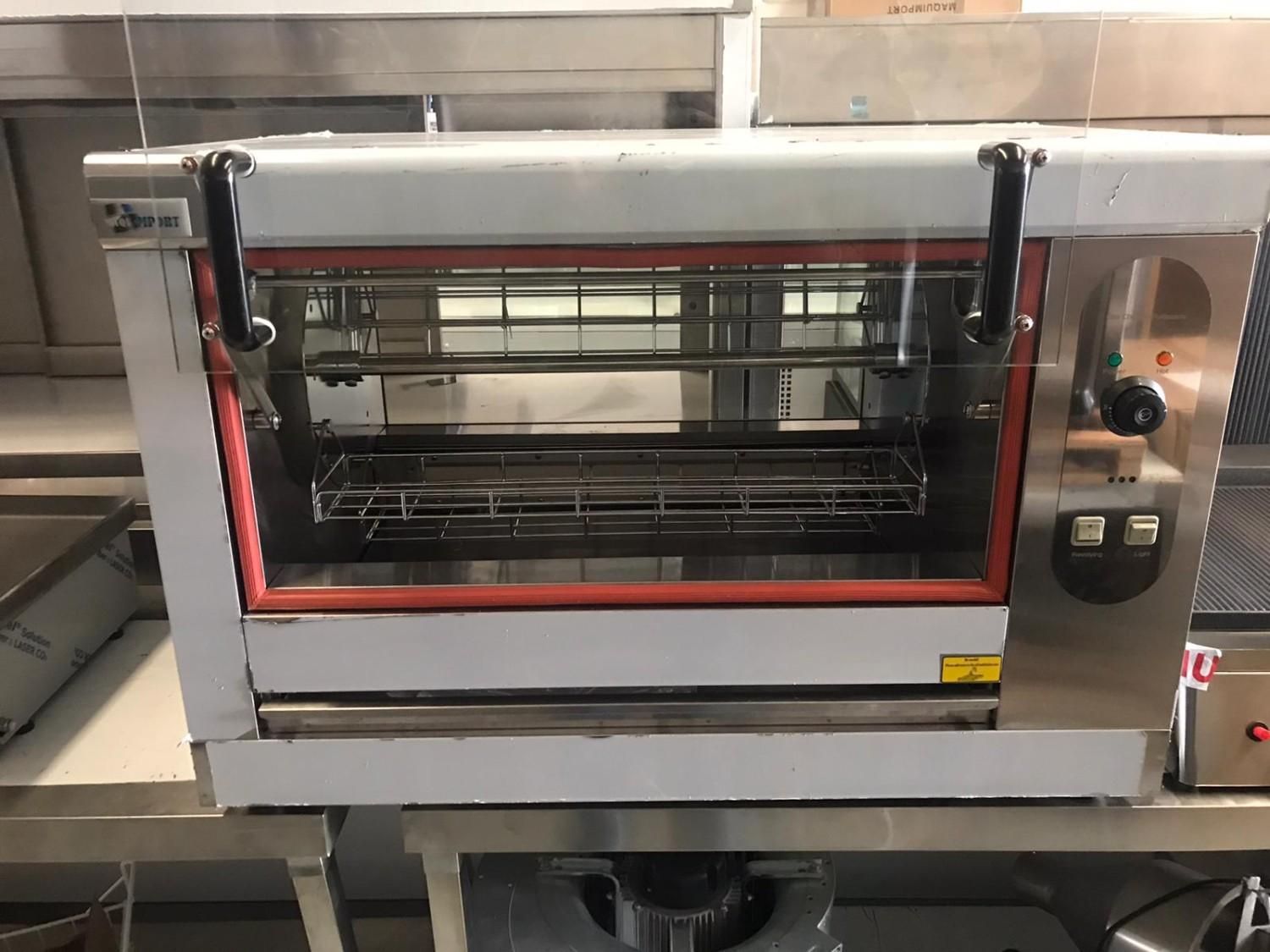 Horno tostador de encimera de acero inoxidable con puerta de cristal y detalles rojos en un entorno de cocina.