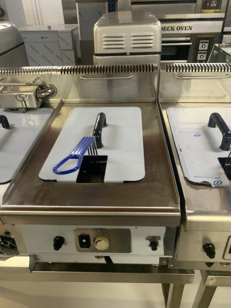 Estación de preparación de alimentos de acero inoxidable con bandejas, utensilios y un cordón azul