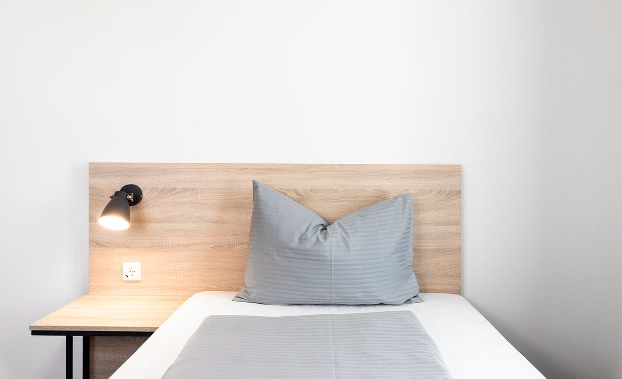 Gemütliches Doppelzimmer mit zwei Einzelbetten, stimmungsvollem Holzdekor und sanfter Beleuchtung.