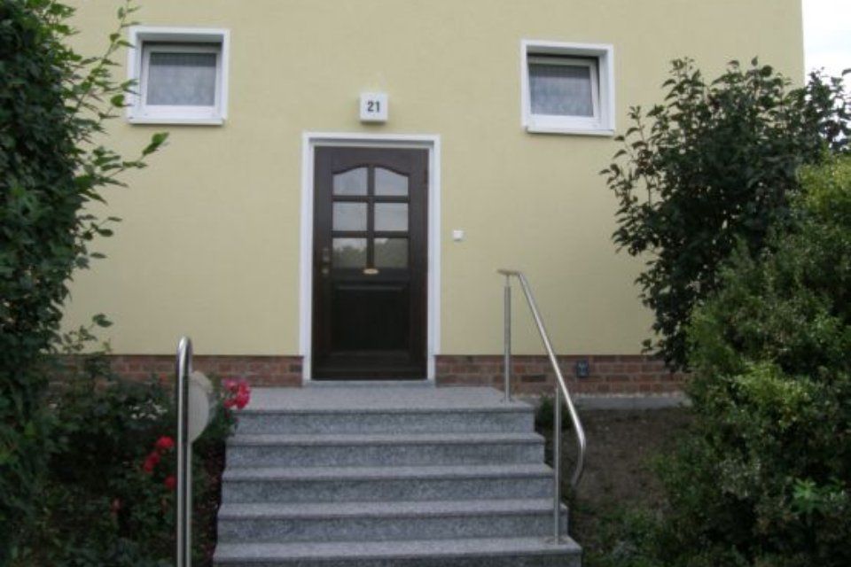 Haus mit heller Fassade und Stiegenzugang