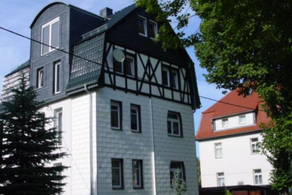 Renoviertes Haus mit heller Steinfassade und Holzelementen