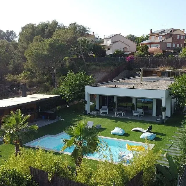 Una vista aérea de una casa con una gran piscina.